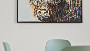 A framed painting of a gorilla's face on a wall.