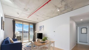 Eine moderne Wohnung mit Wohnbereich, Essplatz und Blick auf die Stadt.