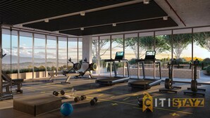 Ein modernes Fitnessstudio mit unterschiedlichen Trainingsgeräten, großen Fenstern und Blick ins Freie.