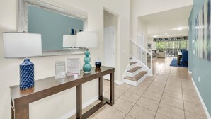 A spacious living area with a staircase, a dining area, and a large window providing natural light.