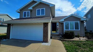 A two-story house with a garage, a brick entrance, and a number '4722' on the door. - Hawthorne Hideaway (West Des Moines)