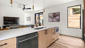 A modern kitchen with a large island, built-in appliances, and pendant lighting. - The West Twin Oasis - Hot Tub near Downtown Austin (Austin)