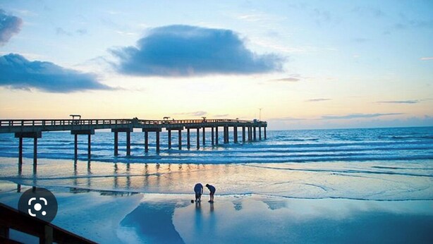 Un muelle se adentra en aguas tranquilas bajo un cielo despejado.