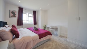 A bedroom with a bed, a desk, and a wardrobe. - The Grove BR1, Spacious 2 Bedroom Flat Greater London (Bromley)