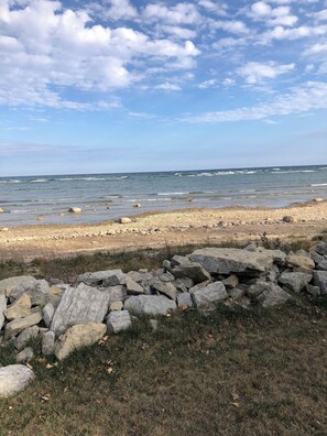 Une plage rocheuse, avec des vagues et un ciel dégagé.