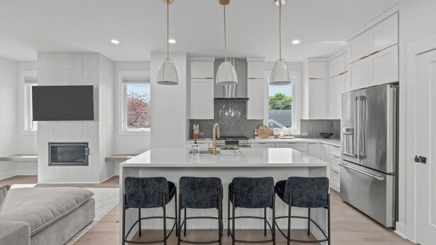 A modern kitchen with a central island, stainless steel appliances, and pendant lighting.
