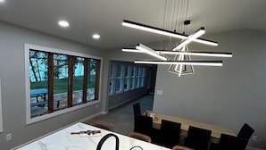 A modern kitchen with a marble countertop, black faucet, and a pendant light fixture.