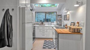 A modern kitchen with white cabinetry, a wooden countertop, and a skylight above the sink. - Stunning Neighborhood Home Walkable to Downtown Mill Valley (Mill Valley)