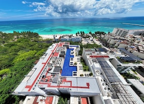 Terraço com piscina, painéis solares e vista para o oceano.