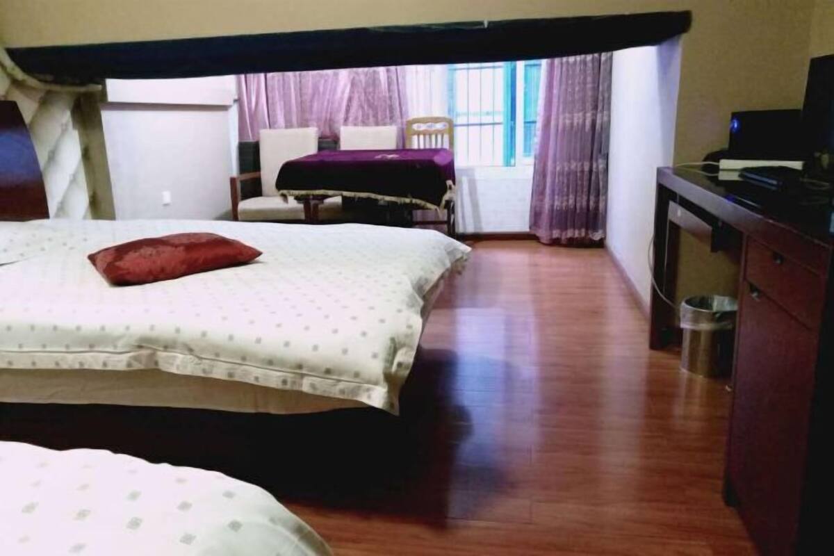 A room with two beds, a desk, and a chair.
