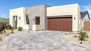 A modern house with a stone facade, a large garage, and a paved driveway. - Resort-Style Gated, Pool Gym Near Downtown Phoenix & Chase Field Hiking Mountain (Phoenix)
