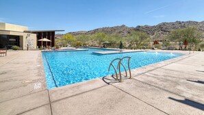 A rectangular swimming pool with a clear blue water, surrounded by a concrete deck. There are lounge chairs and umbrellas around the pool. - Resort-Style Gated, Pool Gym Near Downtown Phoenix & Chase Field Hiking Mountain (Phoenix)