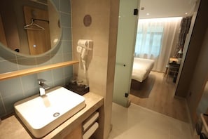 Un baño moderno con lavabo, espejo y secador de pelo.