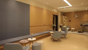 A modern hotel lobby with seating areas, a reception desk, and a decorative wall. - Homeinn · neo (Xi'an Zhonglou Subway Station) (Xi'an)