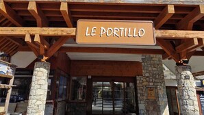 The entrance to LE PORTILLO with a stone pillar and wooden beams. - New for rent, spacious 65m² duplex facing south.  (Val d'Isère)
