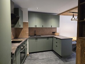 A modern kitchen with a built-in sink, wooden cabinetry, and a countertop.