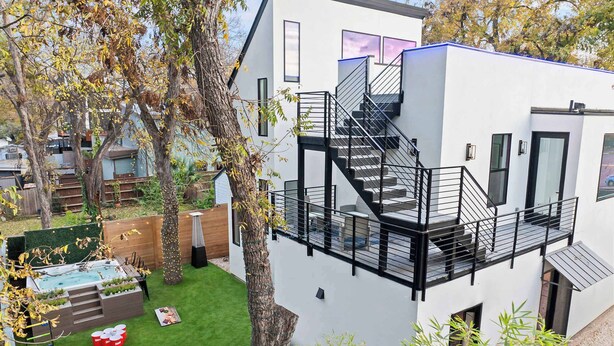 A modern two-story building with a balcony and a staircase.