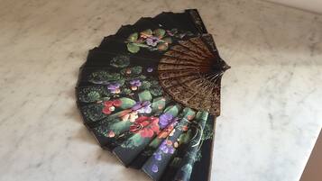Een decoratieve waaier met bloemenmotieven op een marmeren oppervlak.