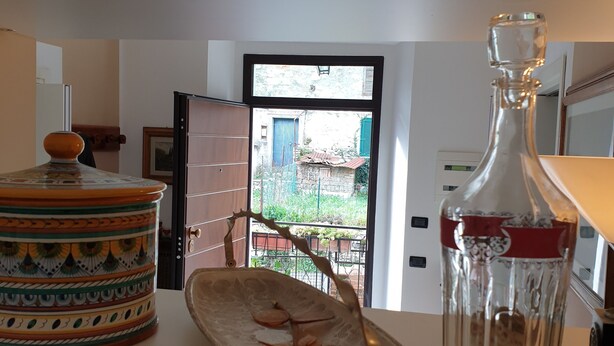 A kitchen with a large window, a decorative plate, a glass bottle, and a colorful pot. - DUETERRE ROOM & HOST (Amelia)