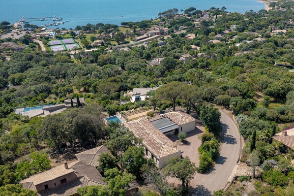 An aerial view of a residential area with houses, a swimming pool, and a dock.