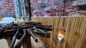 Una mesa de madera rústica con un diseño peculiar, un muro de ladrillo y un panel de madera.