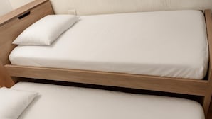 A bunk bed with two pillows and a wooden headboard. - Room AREAS by QuBeLab (Bello)
