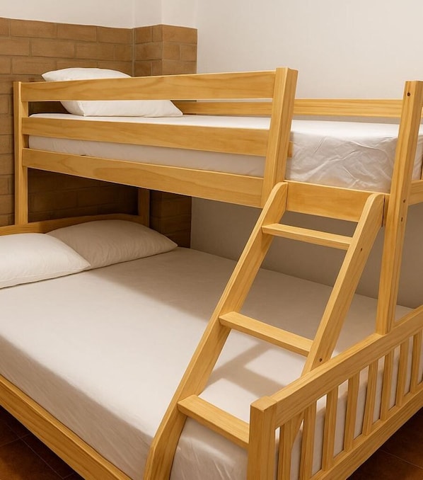 Una cama litera con estructura de madera y una escalera.