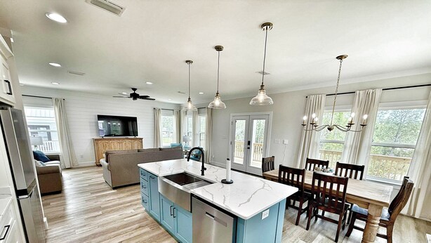 Una cocina moderna con una isla central, mesa de comedor de madera y electrodomésticos integrados.