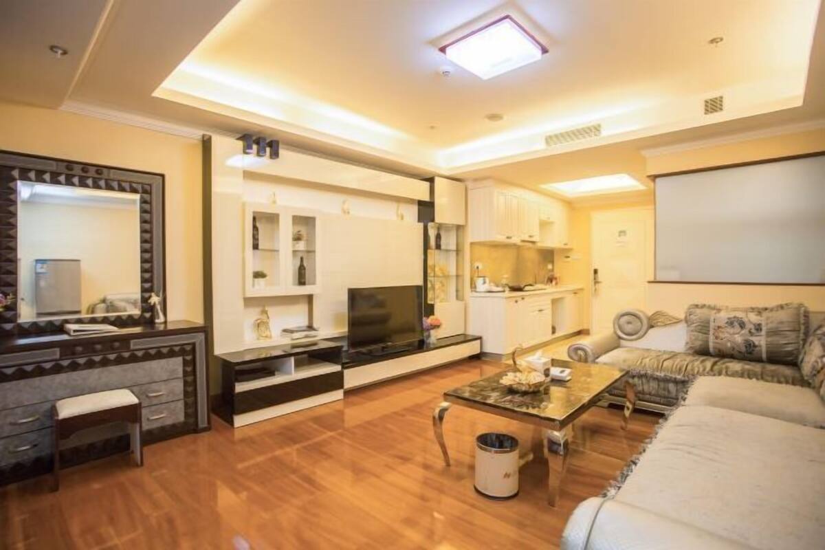 Un salon moderne avec un canapé, une table basse et un téléviseur.