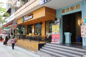 A restaurant with outdoor seating, a staircase leading to the entrance, and a visible storefront. - Hemu International Apartment (Guangzhou)