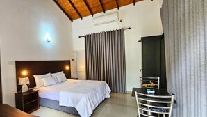 Un dormitorio con cama, mesita de noche, lámpara y una silla.