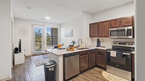 Une cuisine moderne avec des meubles en bois, des appareils électroménagers en acier inoxydable et une grande fenêtre.
