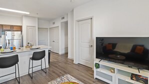 Un appartement moderne comprenant une cuisine, un coin repas et un salon.