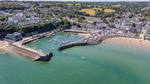 An aerial view of a coastal town with a marina, sandy beach, and residential buildings. - Beachside - Sea Views Village Centre Saundersfoot (Saundersfoot)
