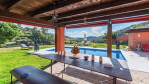 An outdoor pool area with a table set for dining, surrounded by a wooden pergola and a view of the landscape. - Finca Meraki Ojén by Ruralidays (Málaga)
