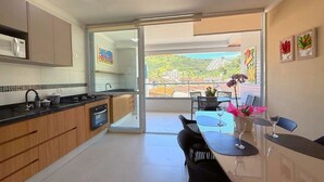 A modern kitchen with a sliding glass door leading to a balcony. - Apt 109 - new, cozy, 150 meters from the beach, we have other apartments. (Ubatuba)