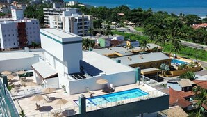 A multi-story hotel with a rooftop pool and a view of the sea. - Apt 109 - new, cozy, 150 meters from the beach, we have other apartments. (Ubatuba)