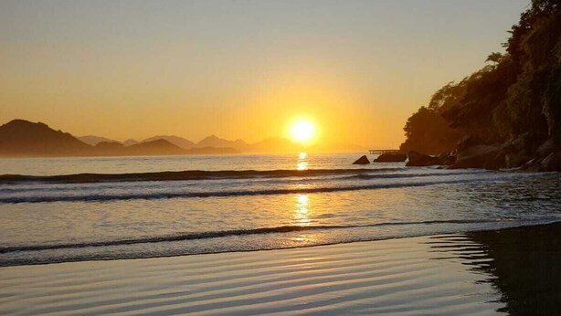 A beach with sand dunes and a sunset over the ocean. - Apt 109 - new, cozy, 150 meters from the beach, we have other apartments. (Ubatuba)