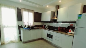 Una cocina moderna con armarios blancos, estufa, horno y refrigerador.