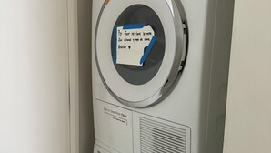 A stacked washer and dryer unit with a note taped to the dryer door. - Tremendous 3-bedroom condo with WiFi in Marina del Rey (Marina del Rey)