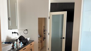 A modern bathroom with a large mirror, a sink, and a toilet. There is a towel rack and a door leading to another room. - Tremendous 3-bedroom condo with WiFi in Marina del Rey (Marina del Rey)