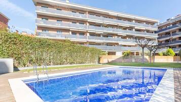 A modern apartment building with a swimming pool.