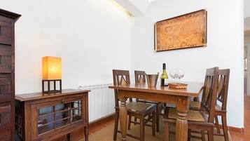Un coin repas avec une table en bois, des chaises, une lampe et une carte accrochée au mur.