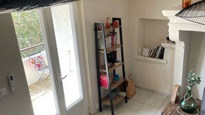 A room with a bookshelf, a small table, and a potted plant.