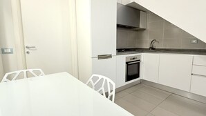 Una cocina con armarios blancos, estufa y lavaplatos.