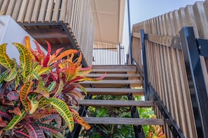 Un escalier avec une rampe en bois et une balustrade en métal.