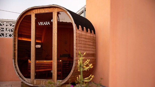 A wooden barrel-shaped structure with the name 'VIKARA' on the door, a small cactus plant outside, and a tiled floor. - Pacific Sun Bargara ~ by the beach (Bargara)