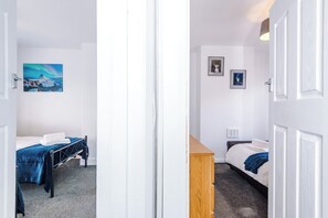 Une chambre d’hôtel avec un lit, une commode en bois et un tableau au mur.
