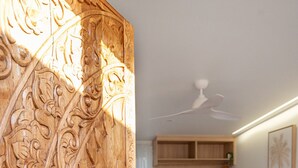 Un dormitorio con cama, mesita de noche, armario y puerta con intrincados grabados.