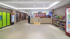 Et hotellets receptionsområde med en receptionsdisk, en automat og en selvbetjeningsskranke.